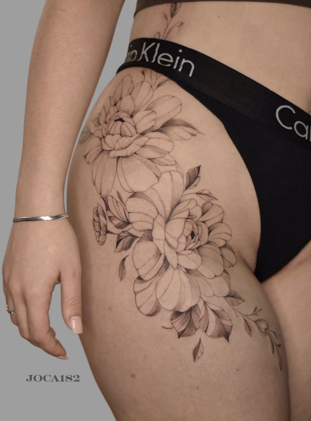 Fine Line Blumen-Tattoo an der Hüfte
